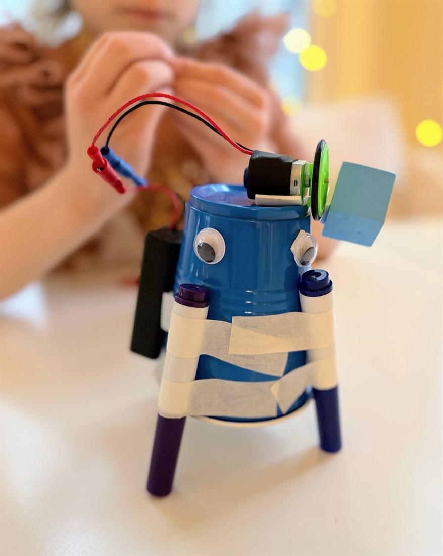 A child at Exploratores wiring the motor on a robot they built from a cup, a battery pack and a propeller