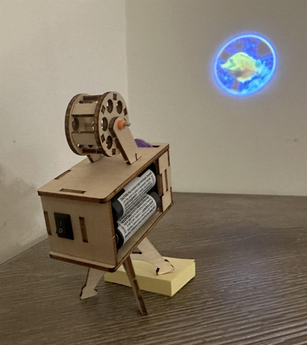 A wooden mechanism part-built on a makerspace bench